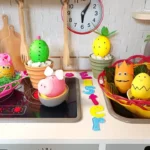 Uskršnja jaja ukrašena kao Minion, zeka, šargarepa, ananas, kaktus i prase, složena na stolu u veselim bojama.