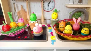 Uskršnja jaja ukrašena kao Minion, zeka, šargarepa, ananas, kaktus i prase, složena na stolu u veselim bojama.